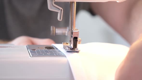 A Man Sews Clothes on Sewing Machine