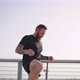 Sportive Man Does Exercise for Legs Before Running Marathon - VideoHive Item for Sale