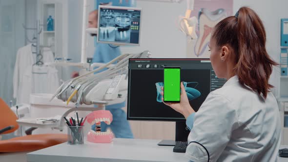 Woman Looking at Green Screen on Mobile Phone alt