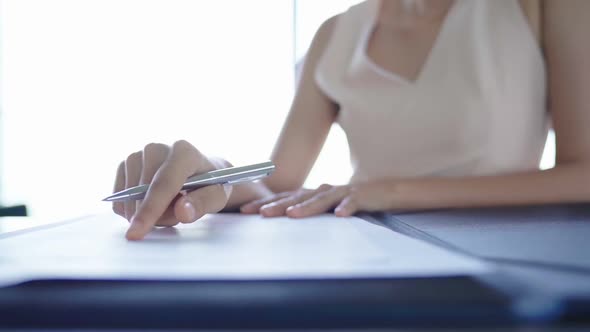 slow motion Mid section of a young asian businesswoman writing, signing documents,contract office ba alt