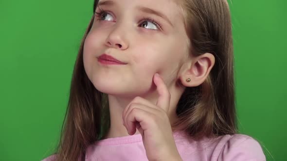Baby Is Looking at the Side, She Is Thoughtful. Green Screen. Close Up. Slow Motion alt