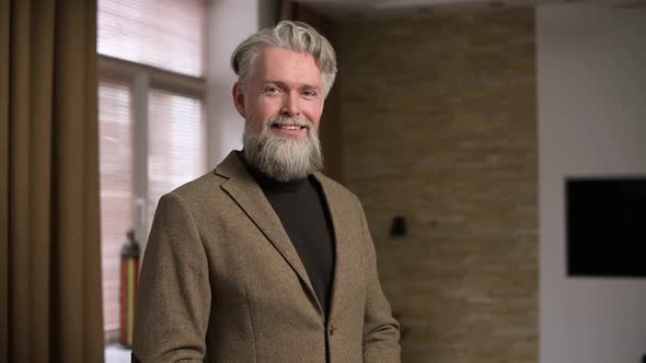 The image of a stylish smiling gray-haired man with a beard alt