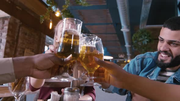 Beautiful Caucasian woman proposing a toast and drinking beer with friends