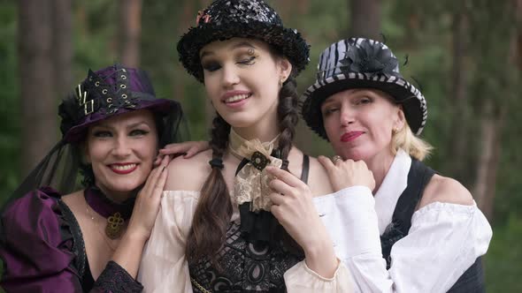 Young Attractive Woman Looking at Camera Smiling with Friends Hands on Shoulders alt