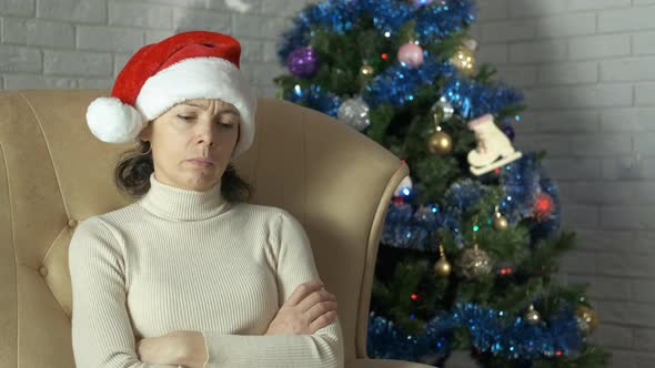 Unhappy lady by Christmas tree. alt