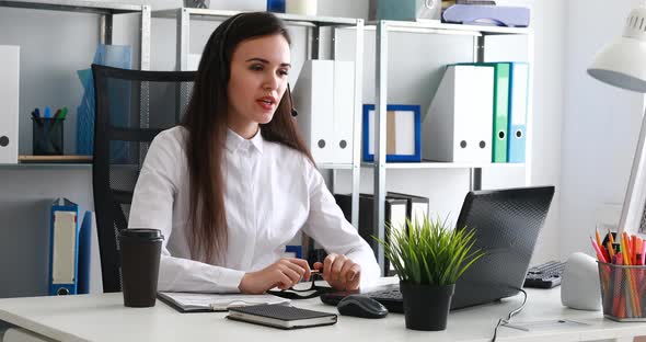 Woman Speaking on Headset in Modern Office