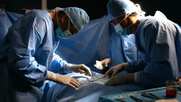 Surgeons performing operation in operation room alt