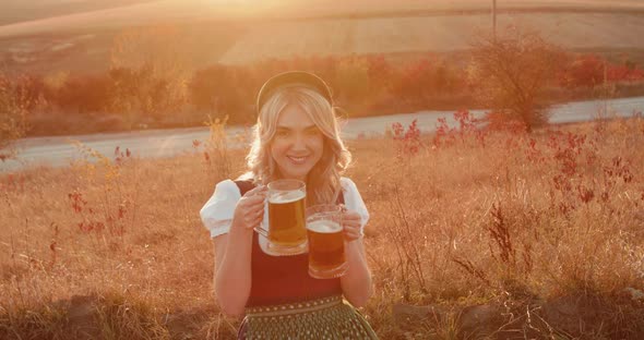 Pretty Slavic Girl in Ethnic Dress Cheers Two Pints of Beer and Smiles on Nature alt