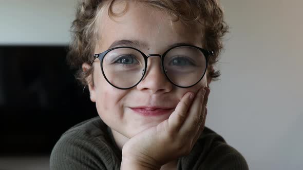 Happy smiling kid with glasses looking into the camera