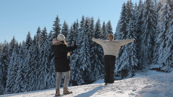 Two Young Woman Having fun on a Winter Day at Mountain, Taking Pictures and Laughing, Slow Motion alt