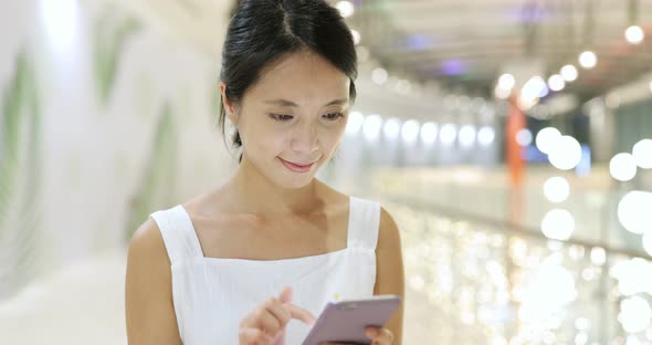 Woman use of cellphone and walking in the shopping mall alt