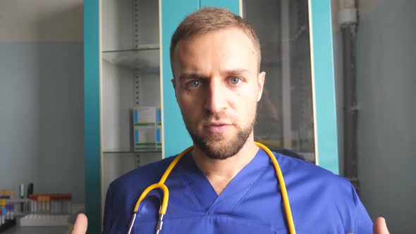 Portrait of Professional Male Doctor Talking and Looking Into Camera alt