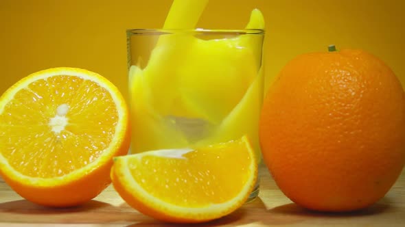 Freshly Squeezed Orange Juice Is Poured in a Glass Next To the Ripe Oranges alt