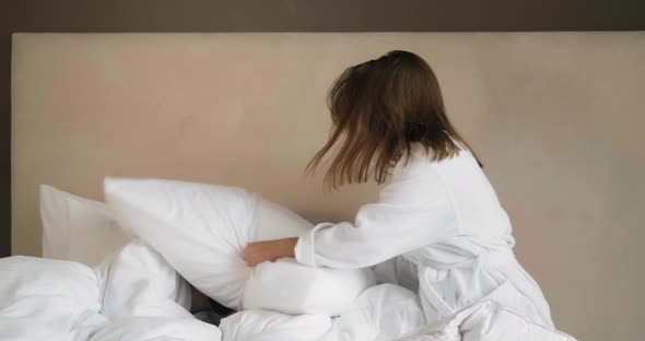 Couple Has Pillow Fight on Comfortable Bed in Hotel Room