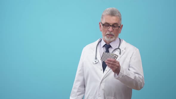 Man Doctor Holds with Pills in Hand and Explains Pharmaceuticals and Instructions to the Use of alt