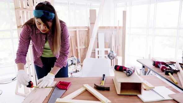 Stylish craftswoman working in carpentry. Woodwork and furniture making concept. alt