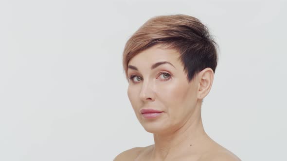 Close-up of middle aged mature woman over white background. alt