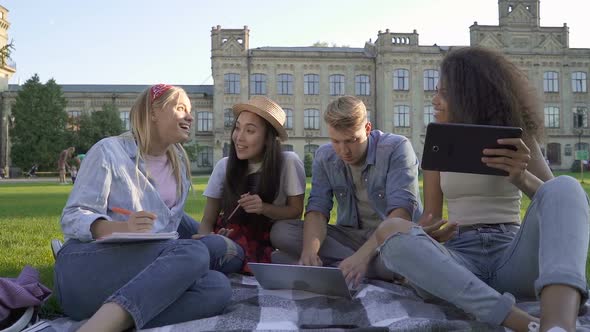 Group of students sitting on the green grass