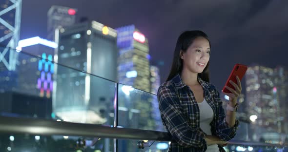 Woman use of mobile phone in city of Hong Kong at night
