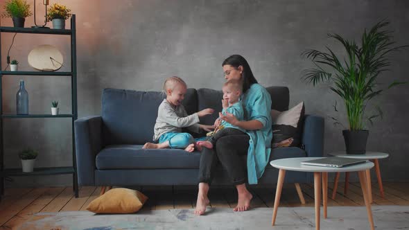 Young Mother Playing with Children on the Couch