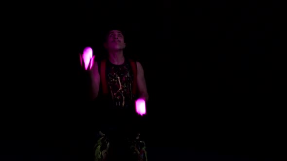 Juggler Showing Tricks with Light Balls in the Whole Dark