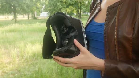 Sexy Young Woman Looking At A Virtual Reality Helmet In The Park alt