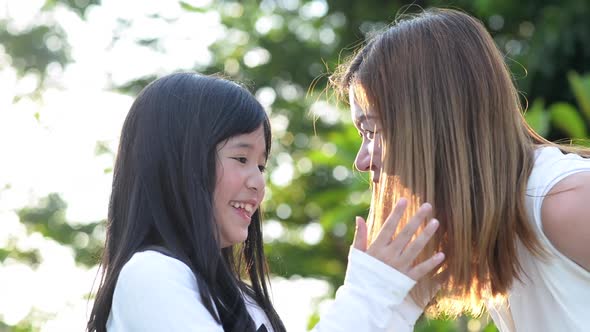 Cute Asian Child And Her Mother Talking Together alt