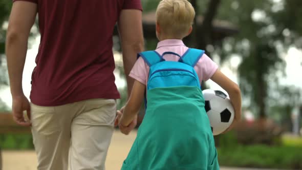 Father Walking Home With Son After School, Discussing Sport Classes, Football alt