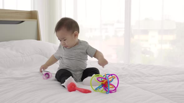 pretty baby play baby toy on bed. 8 months happy baby, Slow motion
