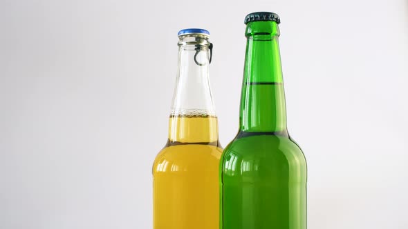Two bottle of beer rotating on white isolated background. 