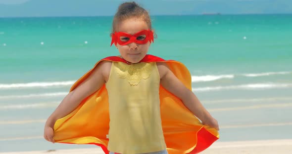 Beautiful Little Girl in the Superhero Costume, Dressed in a Red Cloak and the Mask of the Hero alt