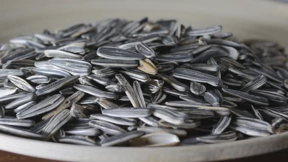 a Lot of Striped Sunflower Seeds Are Poured Onto a Flat Cork Plate