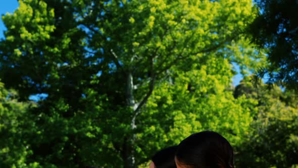 Mother interacting with her son and daughter in park alt