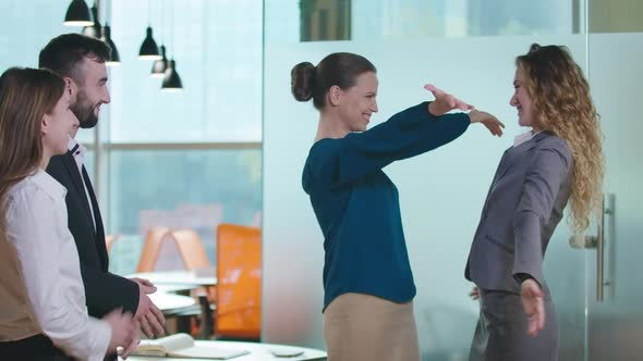 Excited Satisfied Colleagues Hugging As Coworkers Clapping Smiling Standing in Office Indoors alt