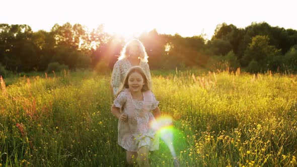 Happy Woman with Daughter in Field
