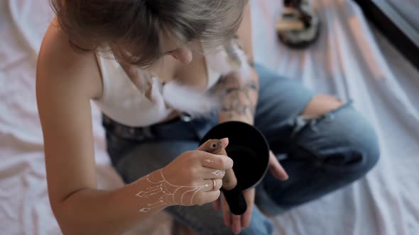 Woman with Chakra Clearing Tibetan Singing Bowl at Home alt