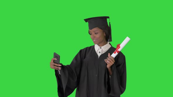 Smiling African American Female Graduate Making Selfie with Diploma on a Green Screen Chroma Key alt