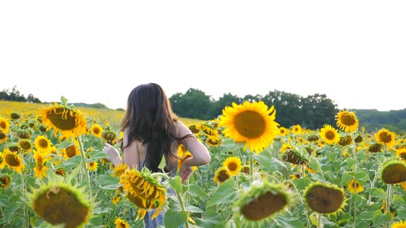 Happy Carefree Girl Running Through Sunflower Field alt