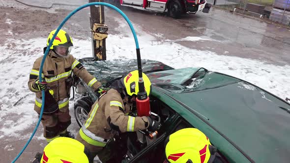 Firefighter Cutting Car Doors with Hydraulic Cutter. Car Accident alt
