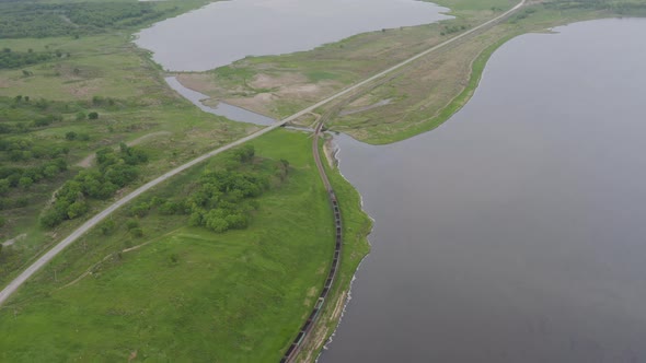 A Drone View of a Freight Train Driven By a Diesel Locomotive on a Railroad alt