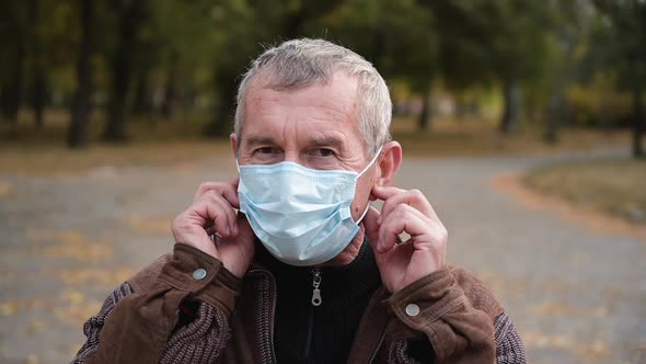 Close Up Portrait of Senior Man Wearing Protective Medical Face Mask. 