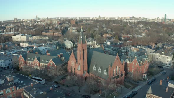Aerial Drone Shot Crossing a Street Towards a Brick Church in Suburban Boston alt