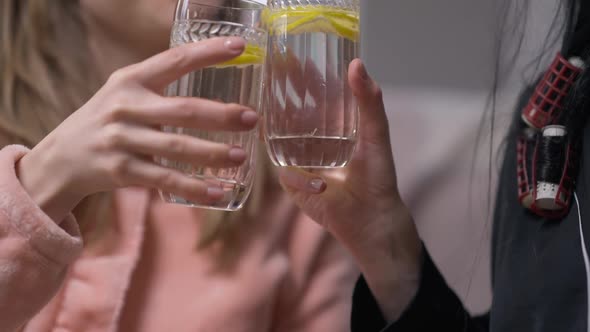 Two Unrecognizable Caucasian Women Clinking Glasses Drinking Refreshing Detox Lemon Water Indoors in alt