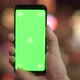 Closeup of Young Man Using Phone with Green Screen Against Illuminated Lights at Night - VideoHive Item for Sale