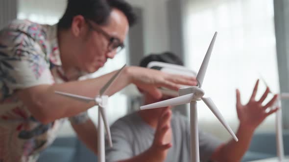 Wind Turbine Model And Blur Teacher Teaching Boy While Wearing VR Glasses alt