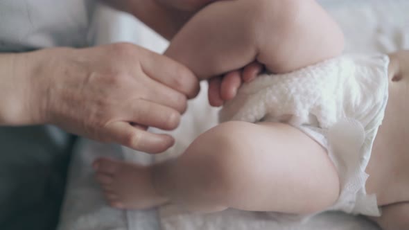 Professional and Skilled Nurse Massages Newborn Baby Legs alt