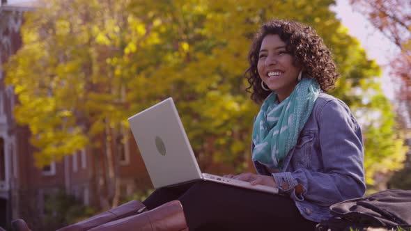 College student on campus in fall using laptop computer