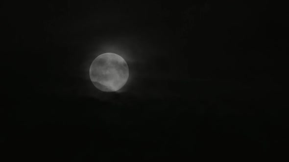 The moon is moving in the dark night sky