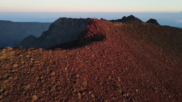 Drone footage of people at the summit of the Piton des Neiges while the sun rises on the Reunion isl alt