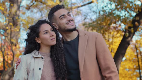Attractive Man Hugging Beloved Wife Hispanic Married Couple Standing in Autumn Park Smiling Spouses alt